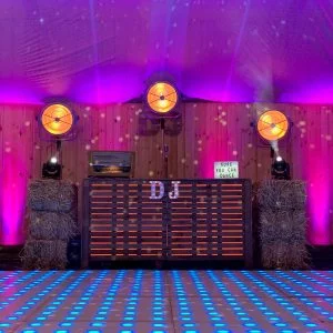 Houten DJ-booth achter een verlichte dansvloer met paarse zaalverlichting